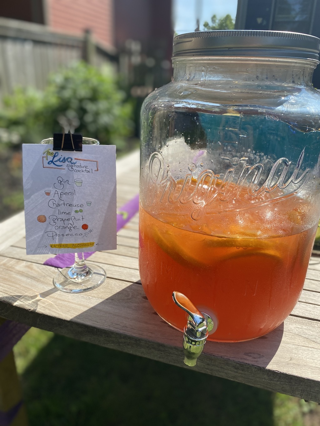 A jar of the custom cocktail, with the recipe on a sheet of paper to the left.