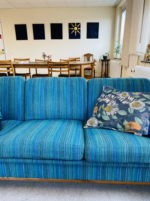 A teal couch in a large creative studio.