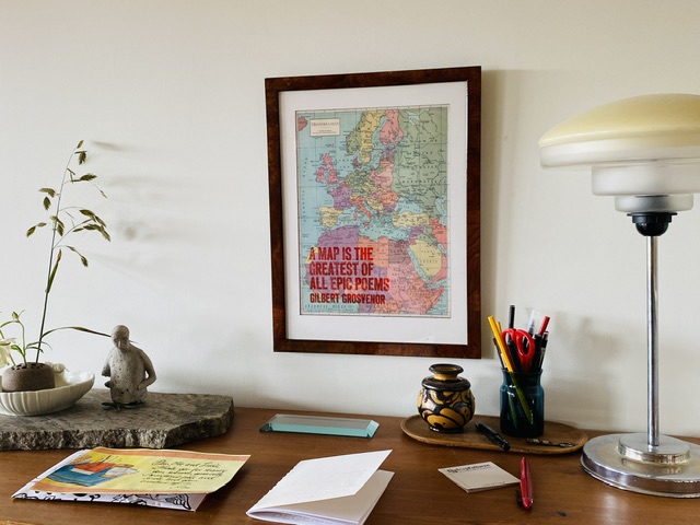 Printed map, framed above a cabinet. 