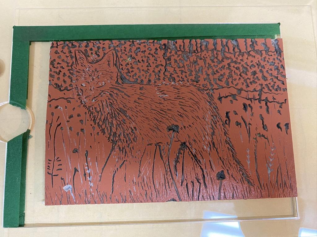 Photo of a lino block of the fox with burnt sienna ink.
